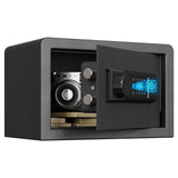 A compact black digital safe with its door open, showing a camera, coins, and cash inside. The safe features a black digital keypad with a glowing blue screen on the door.