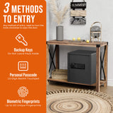 A black home security safe displayed on a wooden console table in a styled room setting, with an orange informational sidebar on the left detailing biometric, personal passcode, and key entry methods.